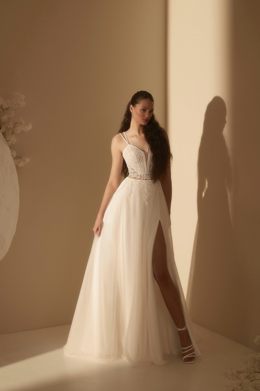 Découvrir la robe de mariée bohème trapèze en tulle fluide SERENA à fines bretelles, un bustier décolleté V en dentelle perlée et une ceinture de dentelle tatouage à Marseille